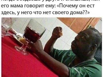 Удивленный негр за столом мем
