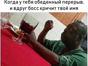 Удивленный негр за столом мем