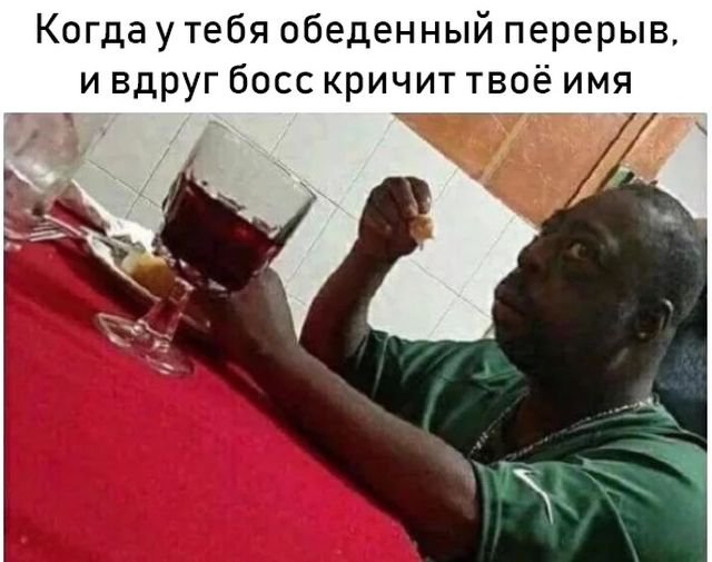 Удивленный негр за столом мем