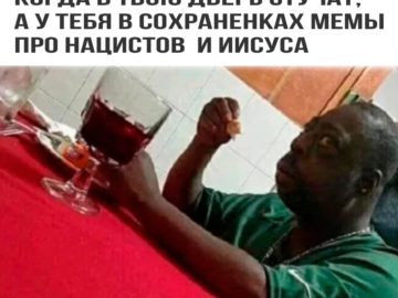 Удивленный негр за столом мем