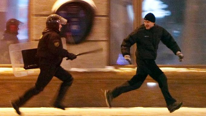 Протестующий убегает от полицейского Протестующий убегает от полицейского